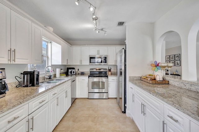 1275 Waterway Cove Dr, Wellington, FL 33414 - kitchen with visible vents, a sink, arched walkways, appliances with stainless steel finishes, and white cabinetry