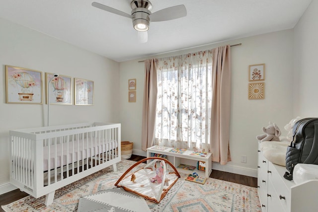 1275 Waterway Cove Dr, Wellington, FL 33414 - bedroom with baseboards, wood finished floors, a nursery area, and ceiling fan