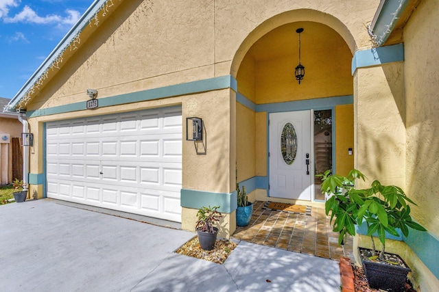 1275 Waterway Cove Dr, Wellington, FL 33414 - doorway to property featuring a garage, driveway, and stucco siding