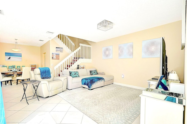 living area with baseboards, light tile patterned flooring, stairs, and visible vents