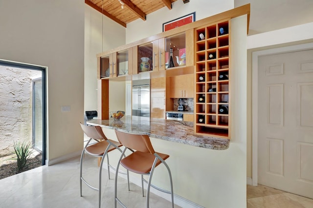 6130 Via Tierra, Boca Raton, FL 33433 - kitchen featuring stainless steel built in fridge, beam ceiling, light tile patterned floors, wooden ceiling, and light stone counters