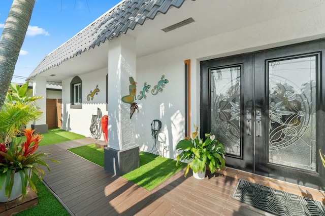 property entrance with stucco siding and french doors