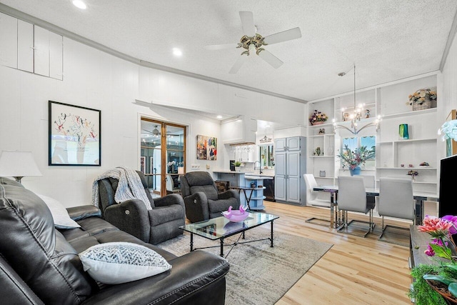 living area with ornamental molding, a ceiling fan, a textured ceiling, and light wood finished floors