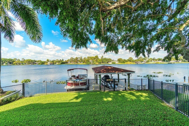 view of dock featuring fence, a yard, and a water view