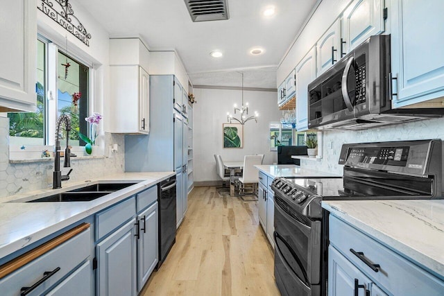 kitchen with a sink, a chandelier, electric range oven, stainless steel microwave, and black dishwasher