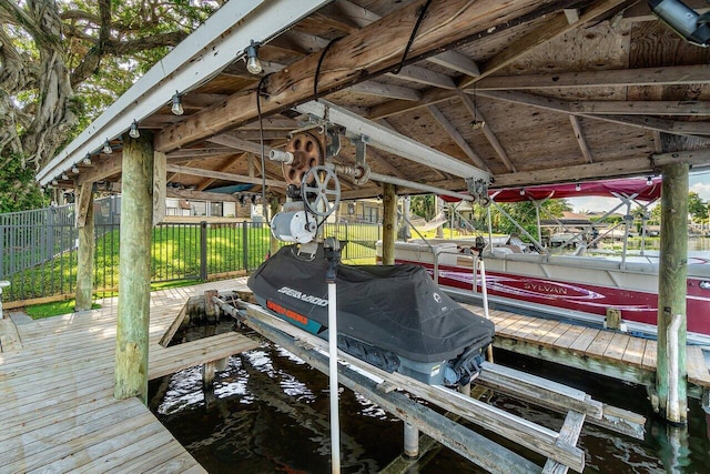view of dock with fence and boat lift