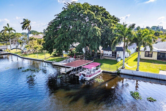 view of dock featuring a yard, boat lift, and a water view