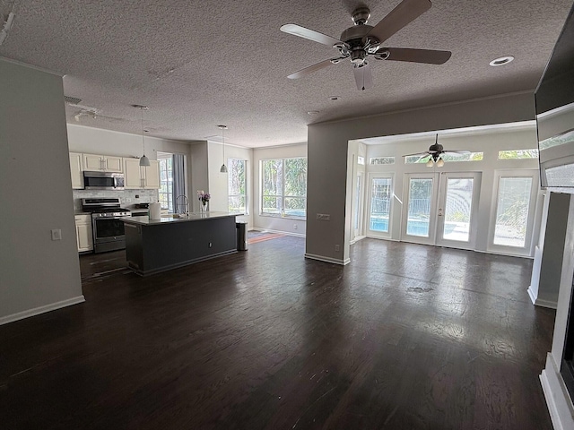 living room featuring a ceiling fan, dark wood-style floors, baseboards, and a textured ceiling