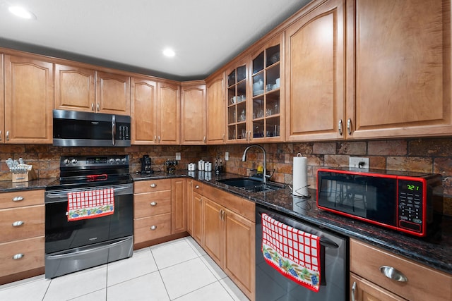 kitchen featuring dark stone counters, electric stove, a sink, stainless steel microwave, and dishwashing machine