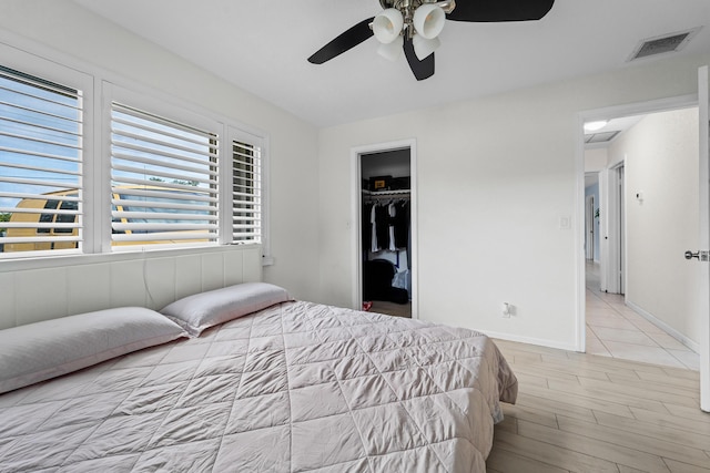 bedroom featuring baseboards, visible vents, a ceiling fan, wood finished floors, and a closet