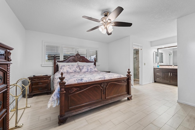 bedroom featuring ceiling fan, a textured ceiling, baseboards, and ensuite bathroom