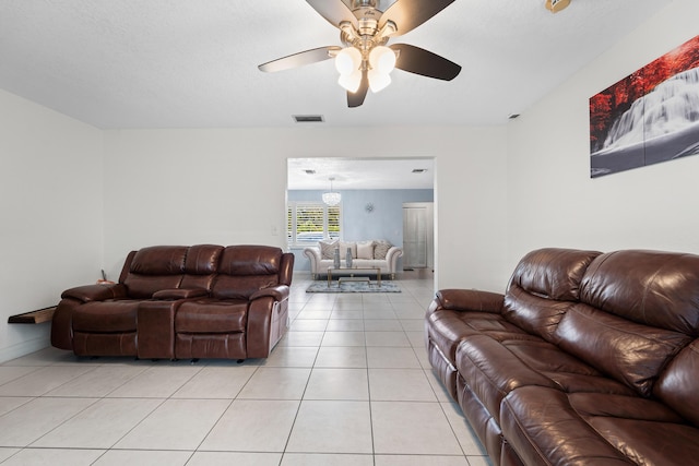 living area featuring ceiling fan, baseboards, visible vents, and light tile patterned floors