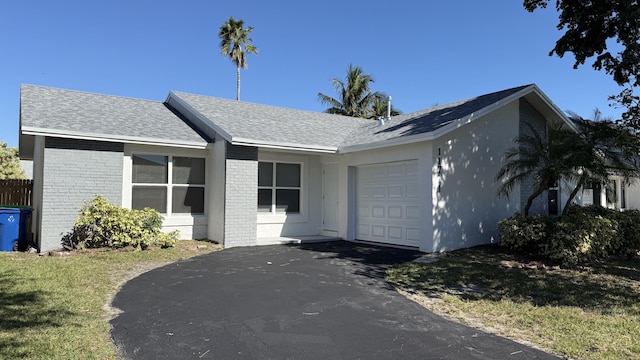 11771 NW 37th St, Sunrise, FL 33323 - ranch-style house with an attached garage, brick siding, aphalt driveway, and a front lawn