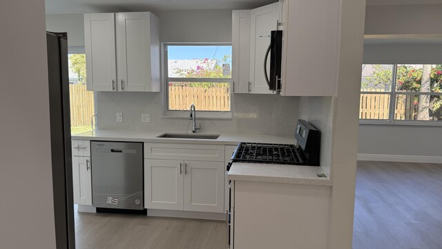 11771 NW 37th St, Sunrise, FL 33323 - kitchen featuring light countertops, a sink, light wood-type flooring, decorative backsplash, and black appliances
