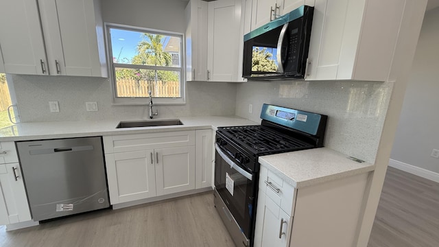 11771 NW 37th St, Sunrise, FL 33323 - kitchen featuring white cabinets, a sink, decorative backsplash, light wood-style flooring, and appliances with stainless steel finishes