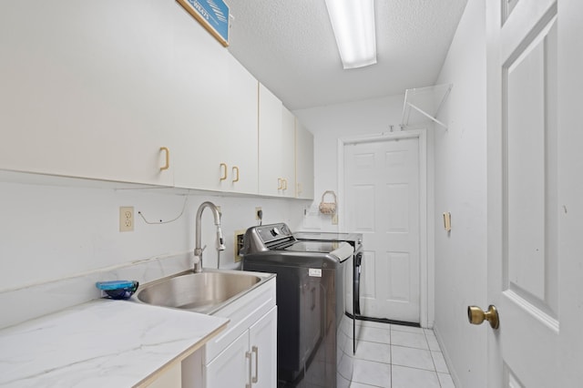 7414 Rosewood Cir, Boca Raton, FL 33487 - laundry area featuring washing machine and clothes dryer, a sink, a textured ceiling, cabinet space, and light tile patterned floors