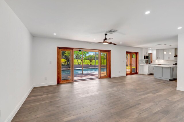 4770 Fox Hunt Trl, Boca Raton, FL 33487 - unfurnished living room featuring baseboards, a ceiling fan, wood finished floors, and recessed lighting