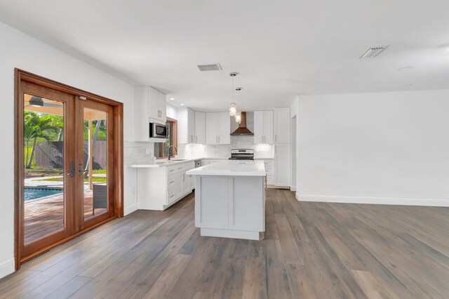 4770 Fox Hunt Trl, Boca Raton, FL 33487 - kitchen featuring wall chimney range hood, stainless steel appliances, a sink, tasteful backsplash, and light countertops