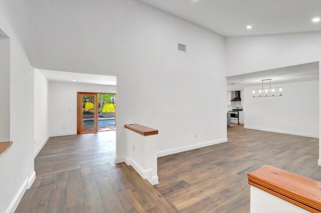 4770 Fox Hunt Trl, Boca Raton, FL 33487 - spare room featuring baseboards, wood finished floors, a chandelier, recessed lighting, and lofted ceiling