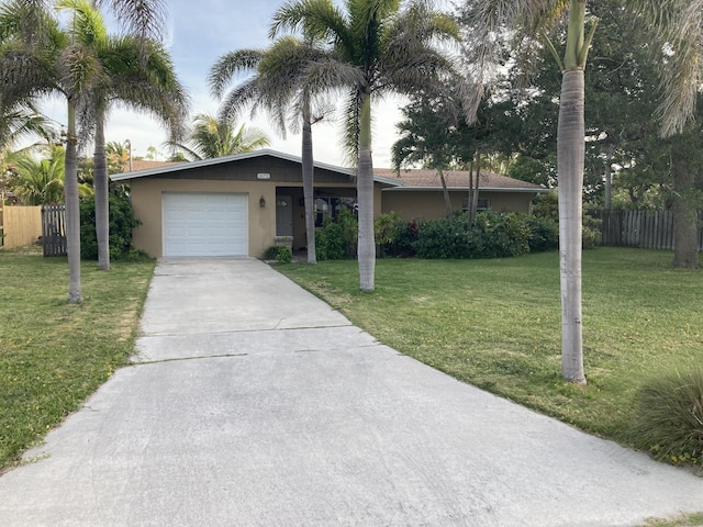 1672 Thumb Point Dr, Fort Pierce, FL 34949 - ranch-style house with fence, stucco siding, a front yard, and a garage