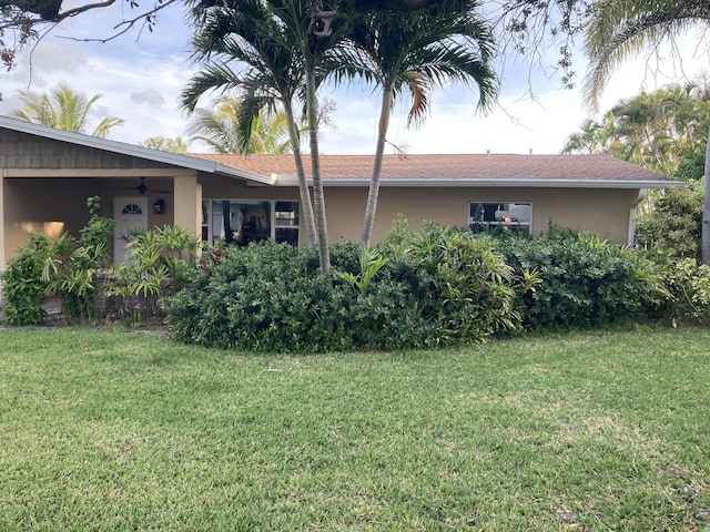 1672 Thumb Point Dr, Fort Pierce, FL 34949 - back of house featuring a lawn and stucco siding