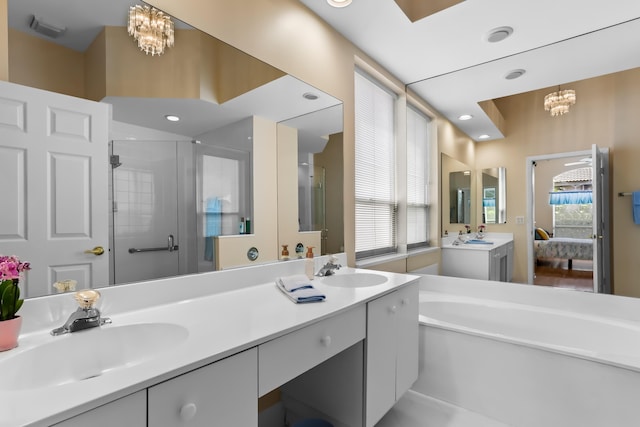 23437 Torre Cir, Boca Raton, FL 33433 - ensuite bathroom featuring a chandelier, double vanity, a shower stall, a garden tub, and recessed lighting
