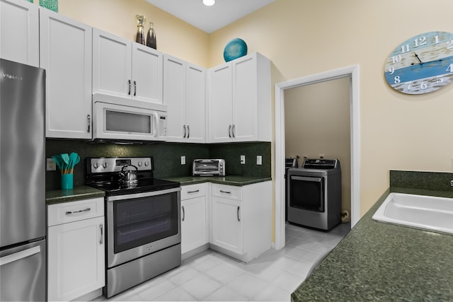 23437 Torre Cir, Boca Raton, FL 33433 - kitchen with appliances with stainless steel finishes, washing machine and clothes dryer, light tile patterned flooring, white cabinets, and recessed lighting