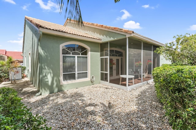 23437 Torre Cir, Boca Raton, FL 33433 - rear view of house featuring a sunroom, a tile roof, french doors, and stucco siding