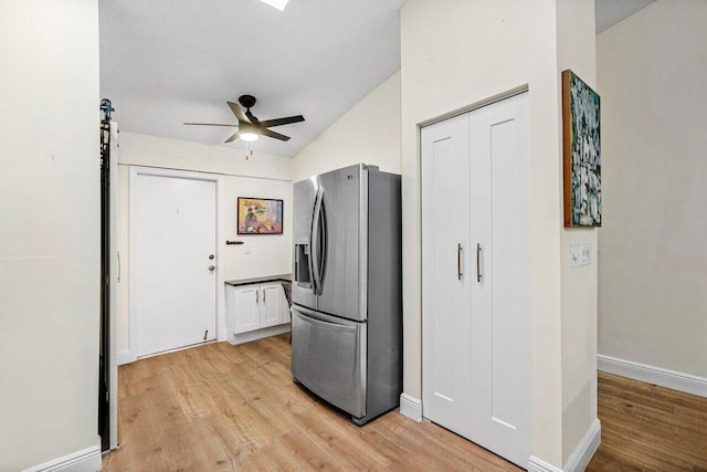 kitchen with baseboards, ceiling fan, light wood-type flooring, white cabinetry, and stainless steel fridge with ice dispenser