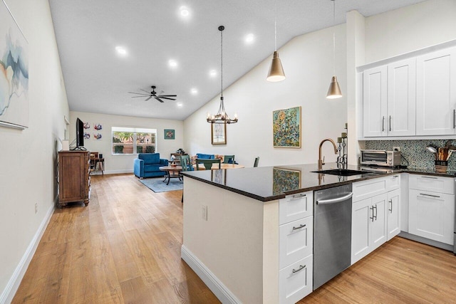 kitchen with stainless steel dishwasher, light wood-type flooring, a sink, white cabinets, and a peninsula