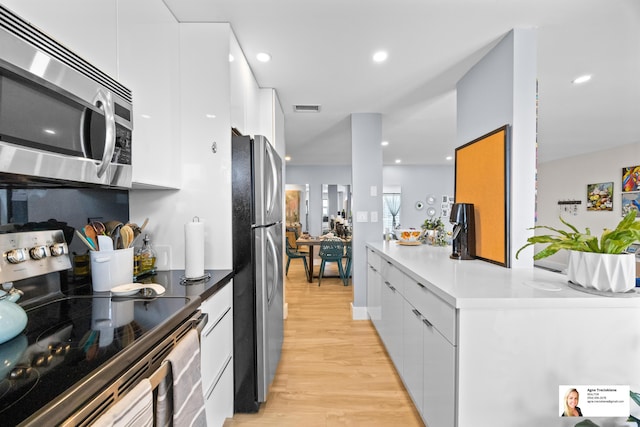 137 Golden Isles Dr Unit 1605, Hallandale Beach, FL 33009 - kitchen with stainless steel appliances, modern cabinets, white cabinets, light wood-style flooring, and recessed lighting