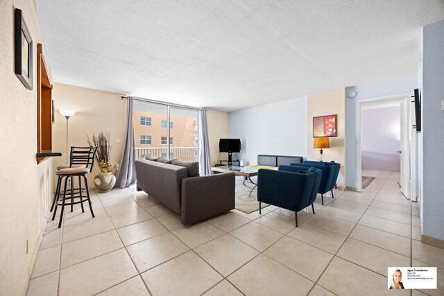 137 Golden Isles Dr Unit 501, Hallandale Beach, FL 33009 - living room featuring light tile patterned floors and a textured ceiling