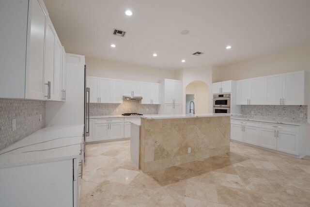 8280 Woodsmuir Dr, Palm Beach Gardens, FL 33412 - kitchen featuring decorative backsplash, white cabinetry, an island with sink, a sink, and recessed lighting