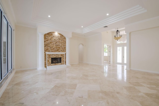 8280 Woodsmuir Dr, Palm Beach Gardens, FL 33412 - unfurnished living room with a tray ceiling, ornamental molding, a stone fireplace, ornate columns, and arched walkways