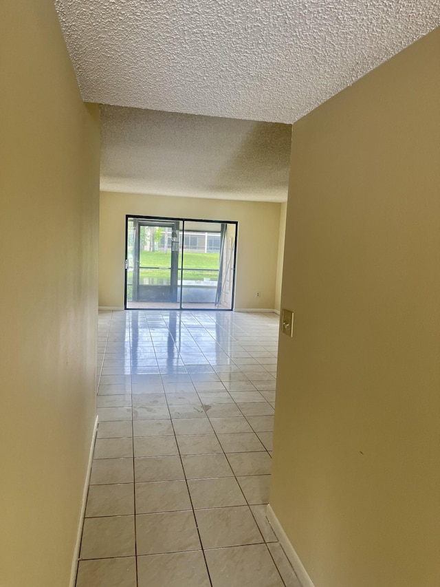 3529 Englewood Dr Unit 313, Lake Worth, FL 33467 - hallway featuring a textured ceiling, light tile patterned floors, and baseboards