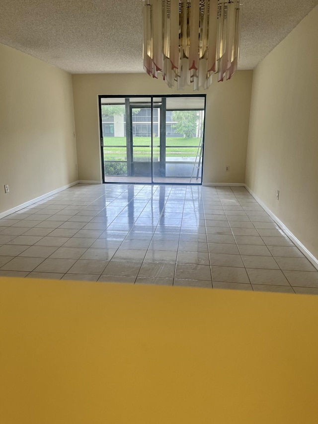 3529 Englewood Dr Unit 313, Lake Worth, FL 33467 - spare room featuring a textured ceiling, light tile patterned flooring, and baseboards