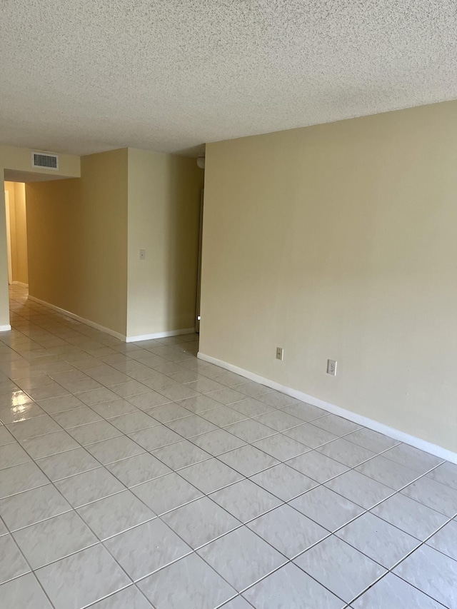 3529 Englewood Dr Unit 313, Lake Worth, FL 33467 - spare room featuring a textured ceiling, baseboards, and light tile patterned floors