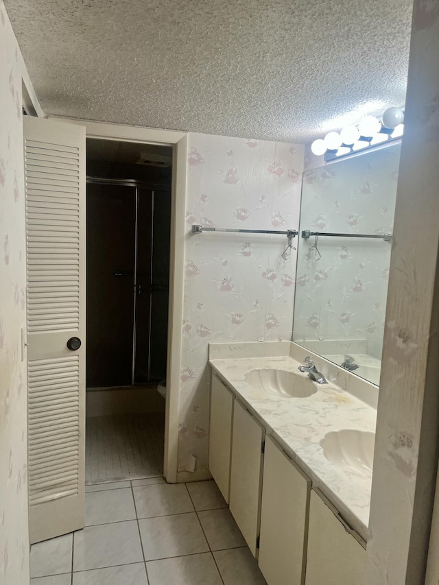 3529 Englewood Dr Unit 313, Lake Worth, FL 33467 - full bath with a textured ceiling, double vanity, tile patterned flooring, wallpapered walls, and a shower stall