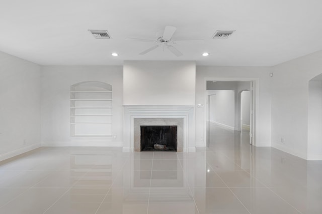 unfurnished living room featuring tile patterned floors, visible vents, and baseboards