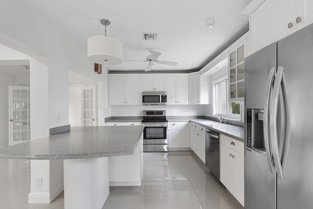 kitchen with a sink, stainless steel appliances, a ceiling fan, visible vents, and a peninsula