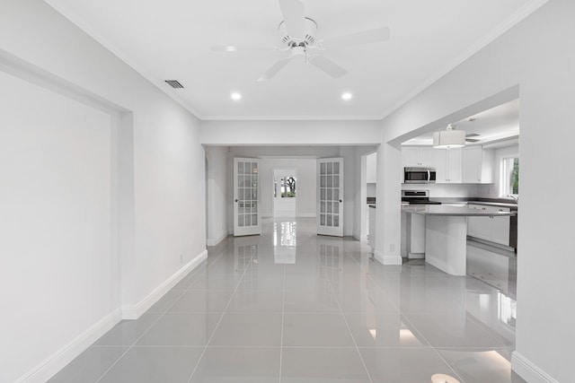 interior space with light tile patterned floors, visible vents, baseboards, ornamental molding, and french doors