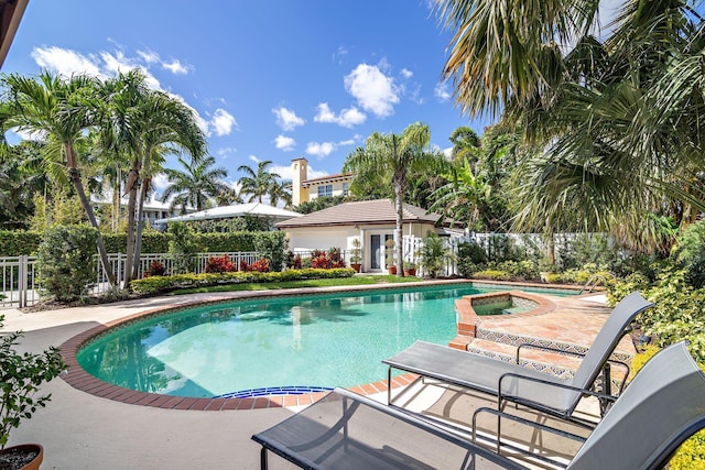 view of swimming pool featuring a patio, an outbuilding, a fenced in pool, an in ground hot tub, and fence