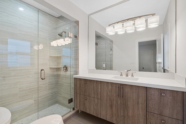 full bath featuring toilet, vanity, and a shower stall