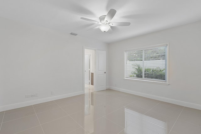 unfurnished room with baseboards, visible vents, light tile patterned floors, and ceiling fan