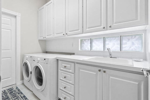 washroom featuring a sink, light tile patterned flooring, cabinet space, and washing machine and clothes dryer