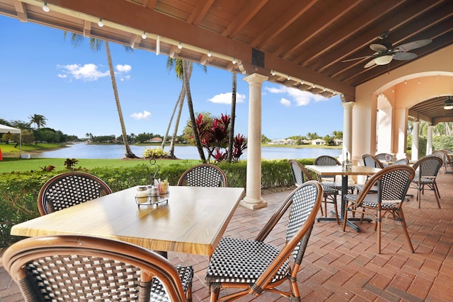 view of patio featuring outdoor dining area, a water view, and ceiling fan