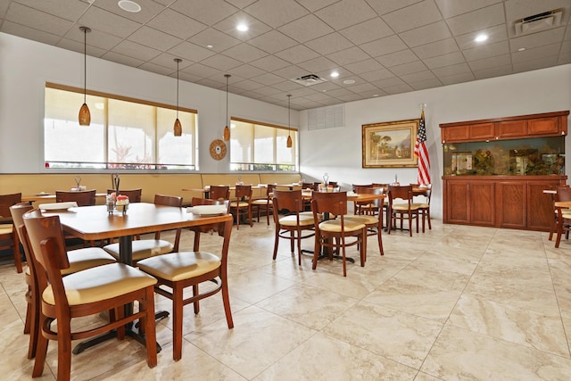 dining area featuring visible vents and a drop ceiling
