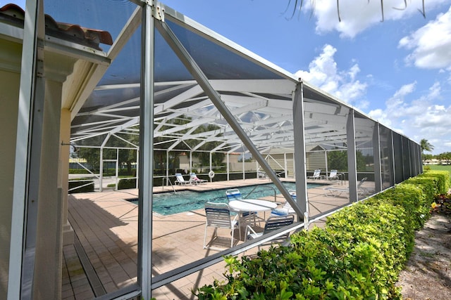 pool featuring glass enclosure and a patio area