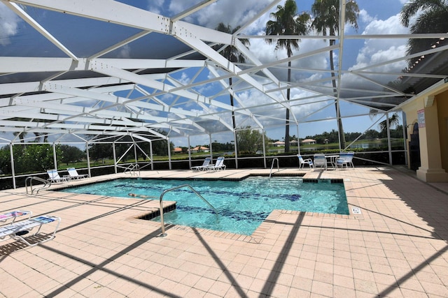 community pool featuring glass enclosure and a patio area