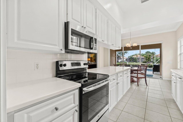 kitchen featuring appliances with stainless steel finishes, decorative backsplash, white cabinetry, and a chandelier